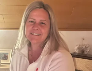 Eine freundliche Mitarbeiterin vom Pflegedienst Kremer für hochwertige Pflege und ambulante Betreuung lächelt in die Kamera für das Teamfoto.