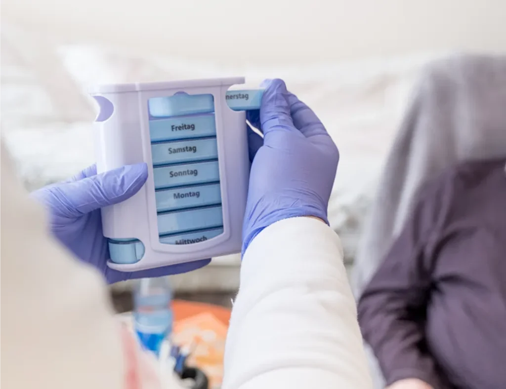 Eine Pflegekraft vom Pflegedienst Kremer bereitet bei der ambulanten Pflege MKK die Medikamente in einem Wochen-Dosierer für einen Patienten vor.