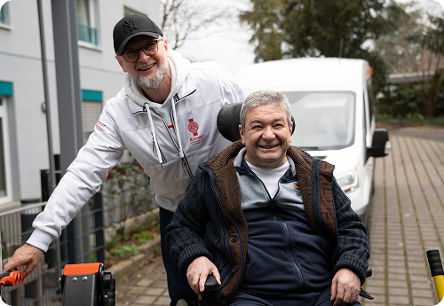 Patrick Kremer vom Pflegedienst Kremer unterstützt einen Klienten im Rollstuhl bei der ambulanten Pflege für die beste Pflege in Deutschland.
